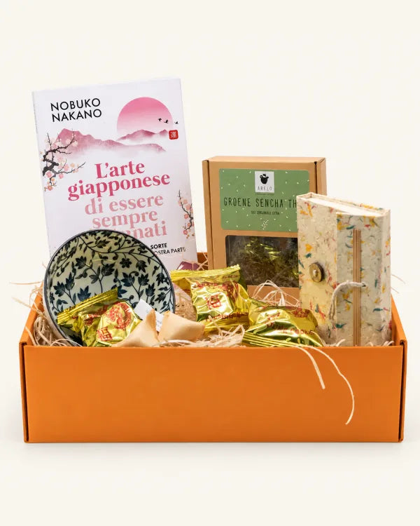 Box arancione con L’arte giapponese di essere sempre fortunati, tè Sencha, quaderno, ciotola e biscotti della fortuna